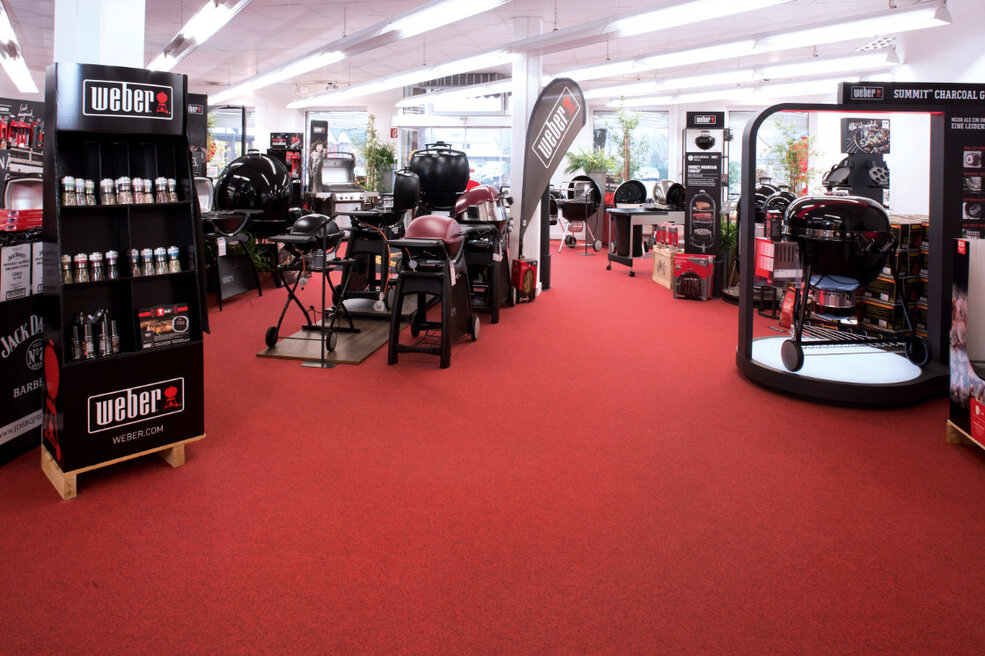 JOKA-Referenzen-Teppich-Einkaufsgeschäft-Rot Raumbild eines Einkaufsgeschäfts, in dem ein knallig roter JOKA Teppich verlegt ist.