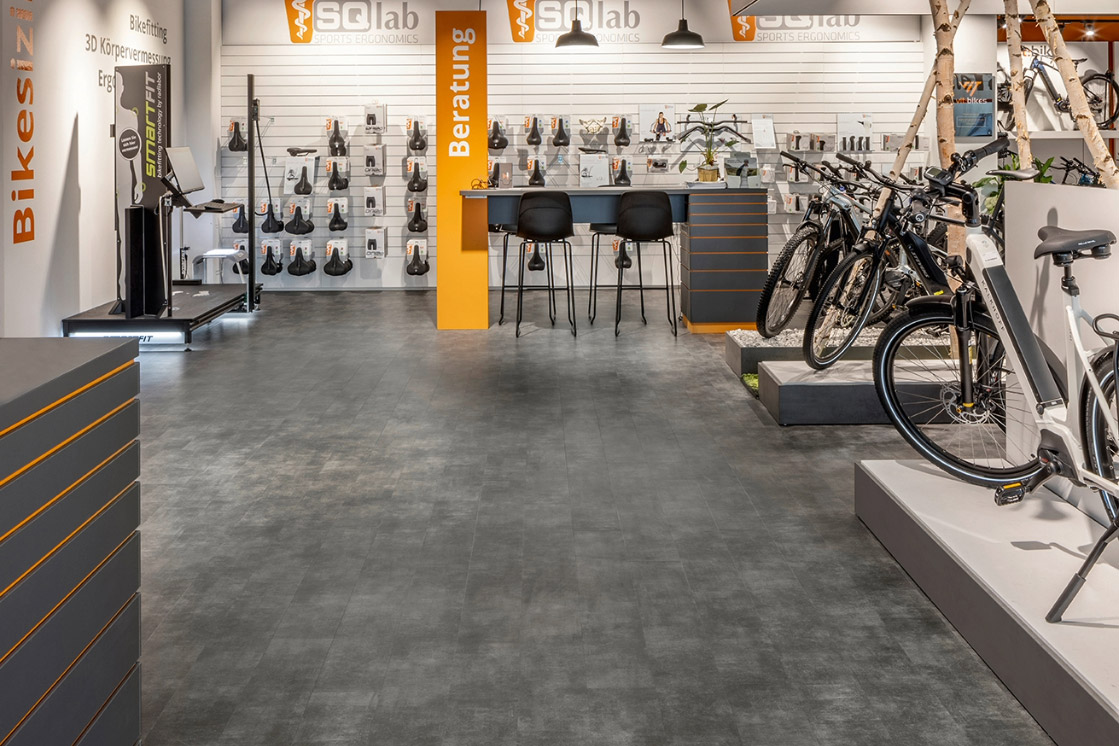JOKA-Referenzen-Designboden-Raumbild-Fahrradhändler Raumbild eines Fahrradladens, in dem der belastbare, dunkelgraue JOKA 340 Designboden verlegt ist.