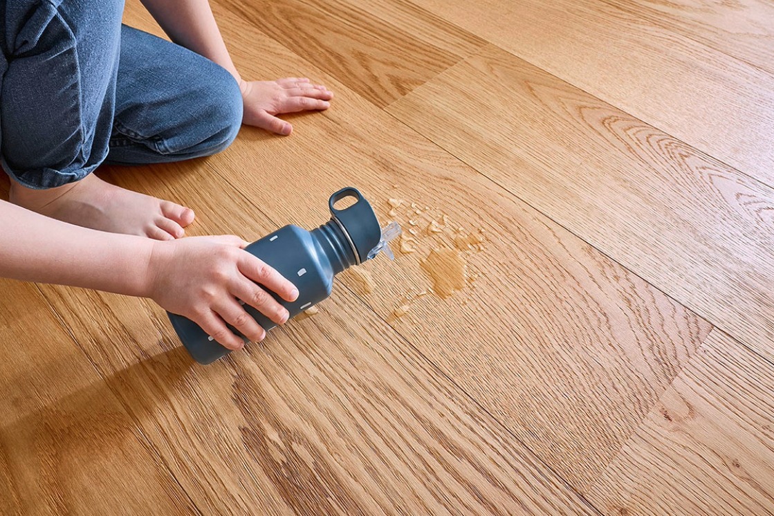 Detailbild des JOKA Naturholzbodens Kjare. Darauf liegt eine Wasserflasche